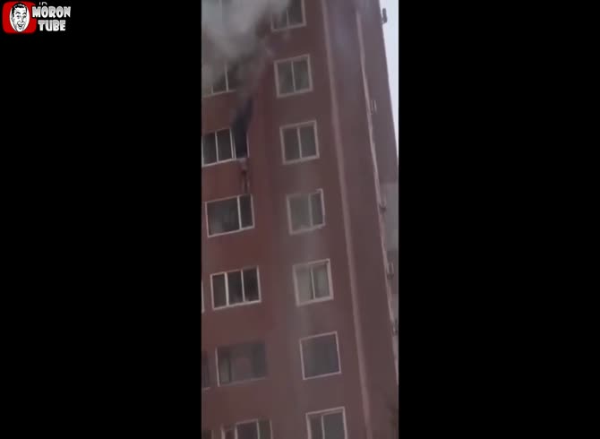 Video :China - A lady anxiously awaits the firefighters' arrival while dangling from the window of her flaming apartment